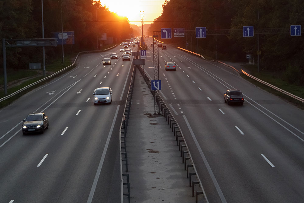 Tráfico denso en una autopista de varios carriles al atardecer, representando el caos y los cambios de carril peligrosos en la I-25 en Denver.